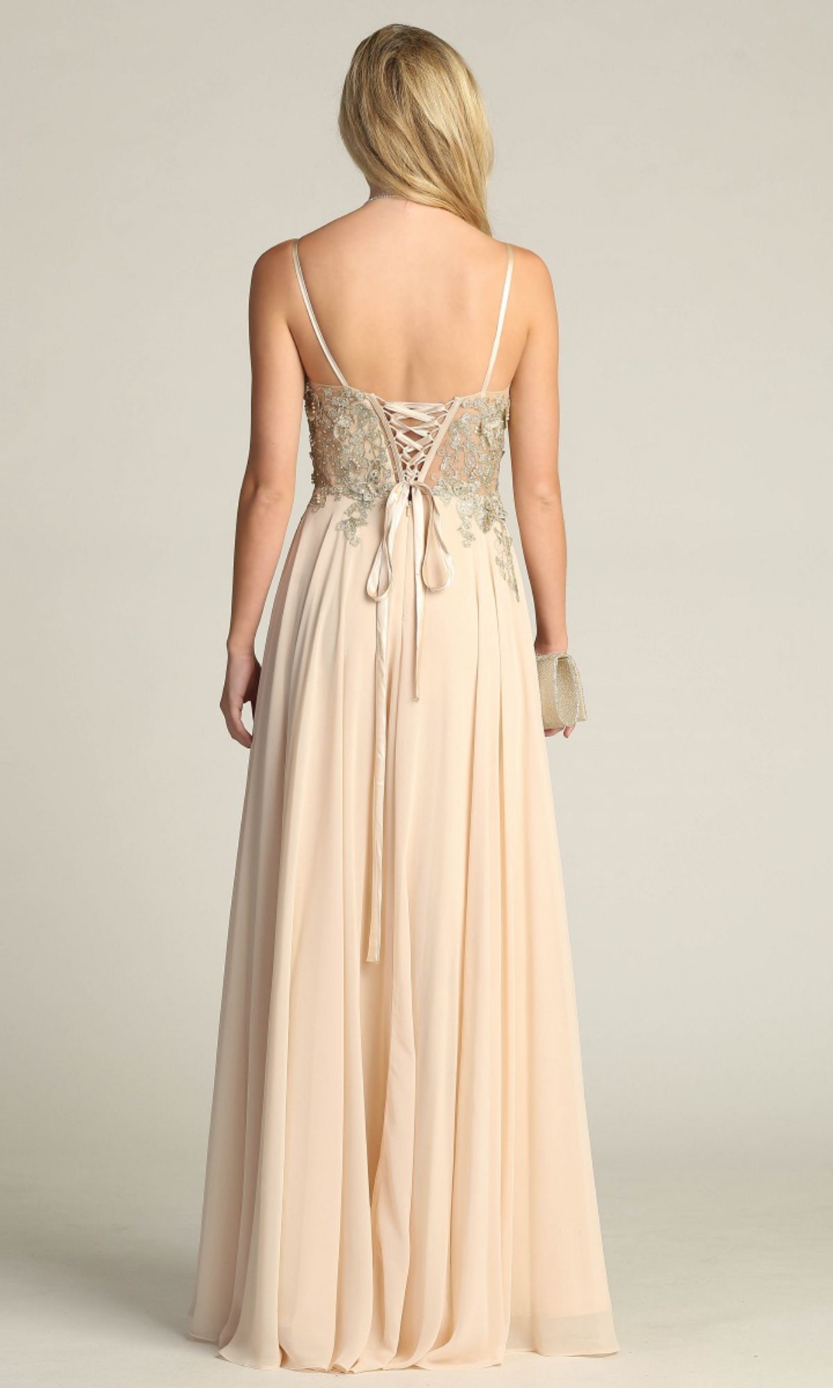 A woman faces away, wearing the Lace-Up Open-Back Long Prom Dress: Chicas C5124, which features a gold embroidered bodice and lace-up back. She holds a small clutch in her right hand.
